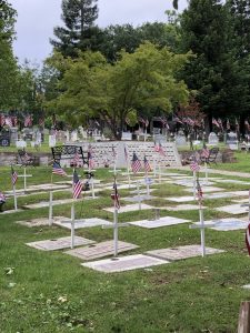 Many flags atop crosses marking graves of veterans donated to the cemetery.